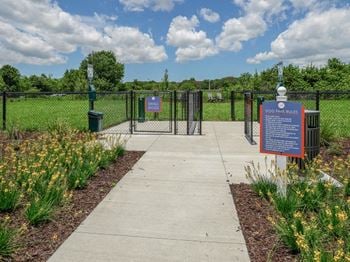A park with a fenced in area and a sign that says dog park